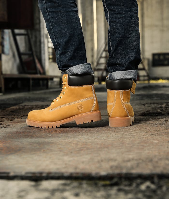 Close-up of yellow work boots on urban pavement, showcasing fashion and style.