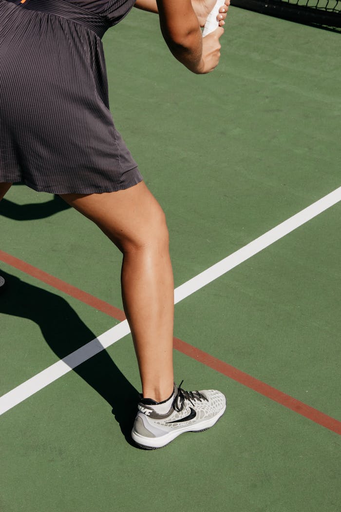 Close-up of a woman on an outdoor tennis court preparing to serve.